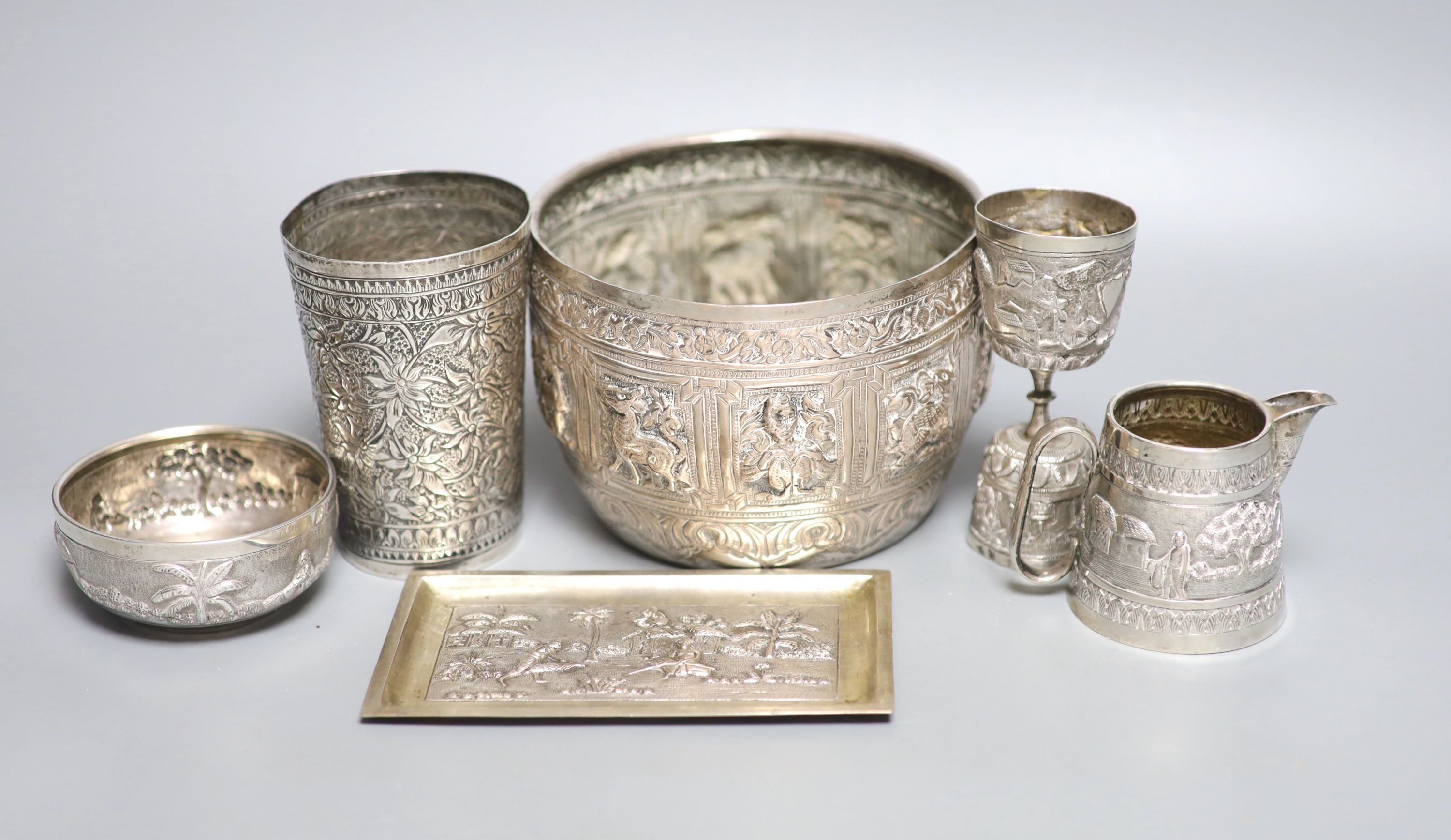 A group of Indian items including a white metal bowl embossed with animals, diameter 14.2cm, cream jug, measure, bowl, dish and beaker.